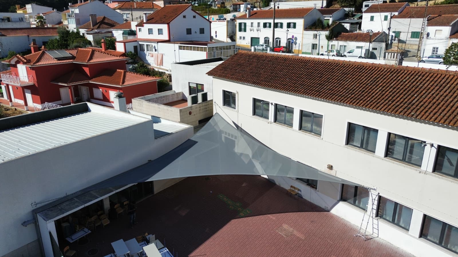 A APG Coberturas instalou uma vela de sombreamento em Loures com rede microperfurada Ferrari 332 cinza, cobrindo cerca de 80 m². Uma solução que assegura conforto, proteção solar e bem-estar em espaços escolares.